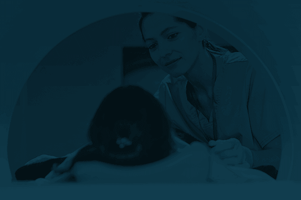 A doctor checking on a patient lying in an MRI machine.