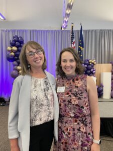 Two women stand side-by-side at an award event.